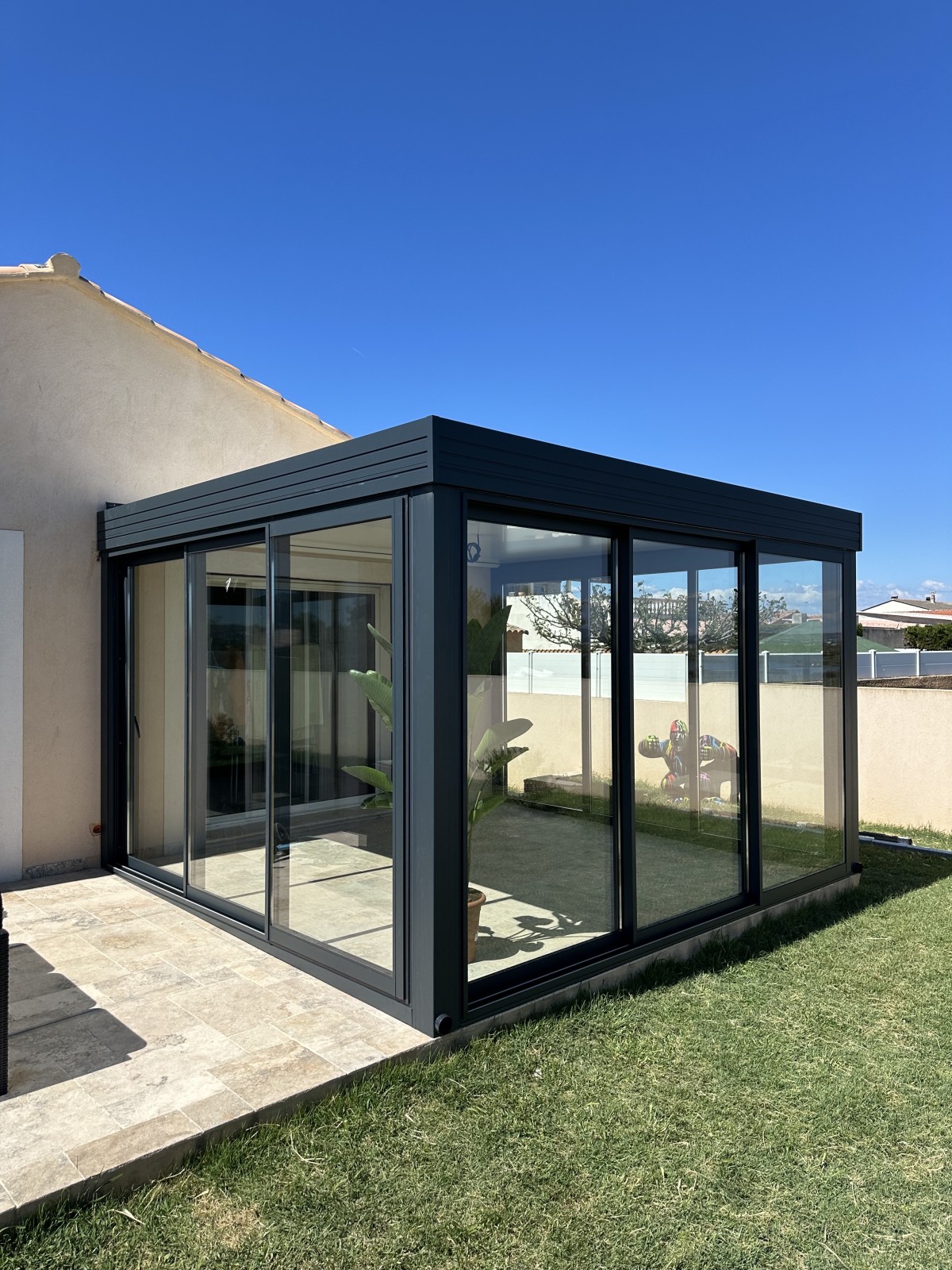 Installation d’une véranda en aluminium avec ses fenêtres coulissantes en verre à Martigues