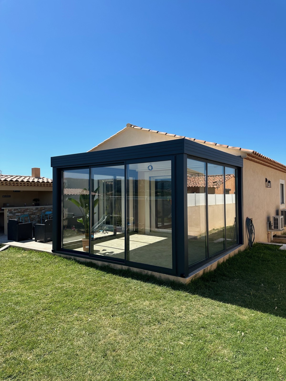 Installation d’une véranda en aluminium avec ses fenêtres coulissantes en verre à Martigues