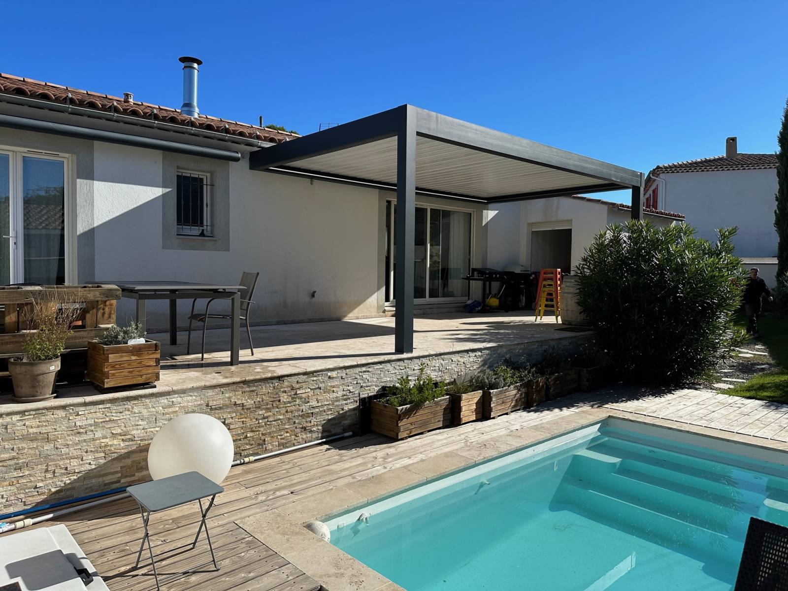 Installation d'une pergola bioclimatique sur mesure à lames blanches avec motorisation Somfy à Sausset les Pins