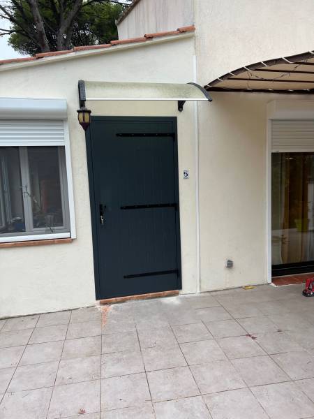 Installation d'un volet battant en aluminium sur mesure pour fermer une porte à Saint Mitre les Remparts